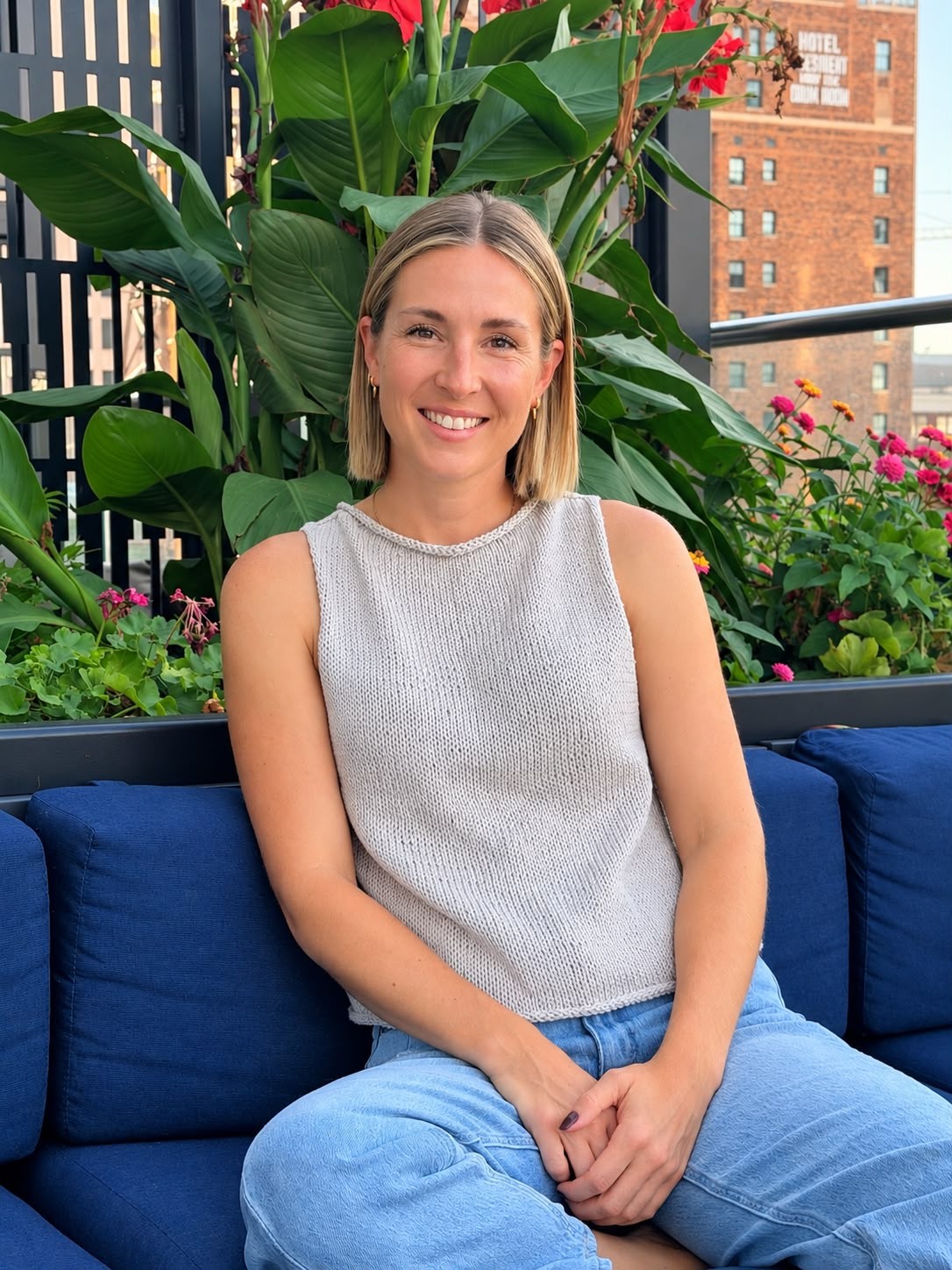 Marie Clifton, LCSW, LSCSW, smiling outdoors among plants and flowers